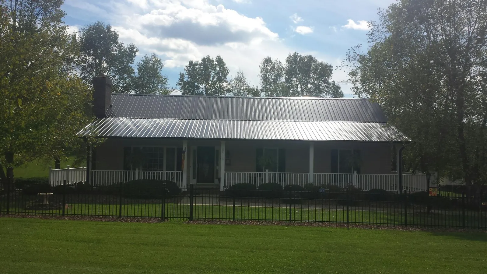Gray metal roof on a brick ranch with a full width front porch — Gutter Guard Installation work by our crew in Elizabethtown